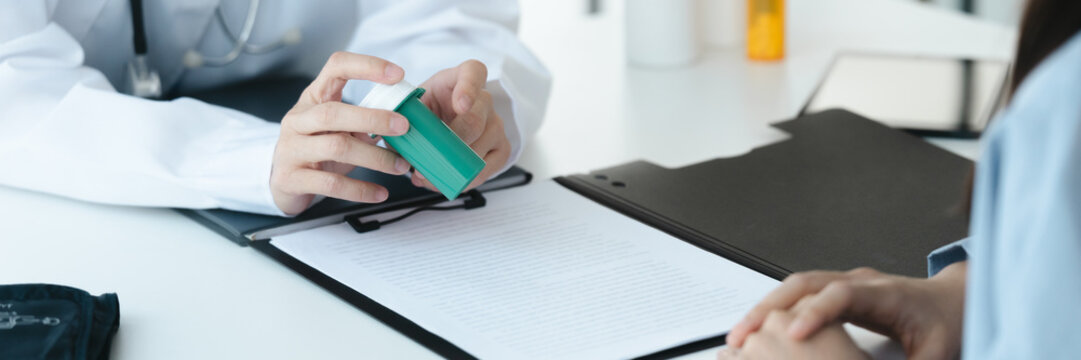 doctor clarifies a drug bottle to a patient in hospital consultation