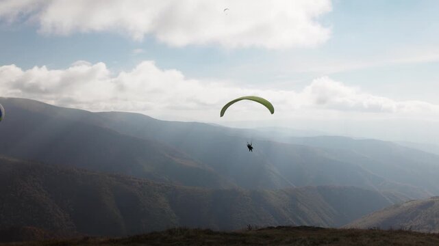Paragliding in highland against giant forestry mountains