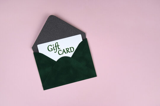 Gift voucher in a green envelope on a light background