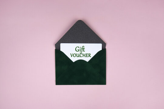 Gift voucher in a green envelope on a light background