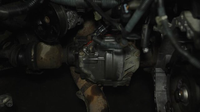 Bottom view of a car front differential and cv joint assembly.
