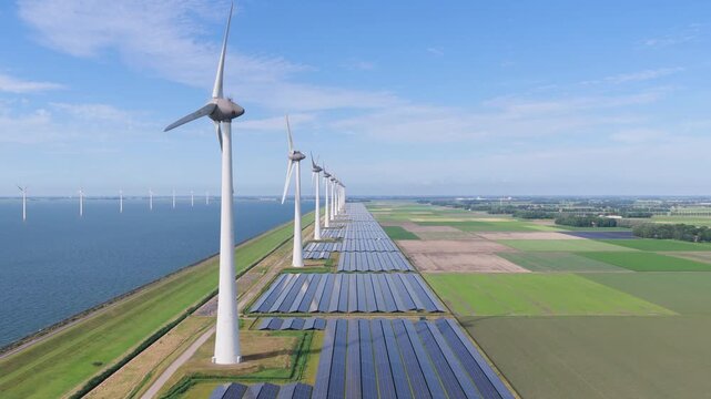 Aerial drone view of solar panels and wind turbines in a renewable energy farm. Sustainable green power station for clean electricity production and environmental technology infrastructure.