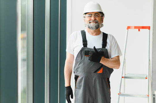 Experienced construction worker installing windows giving thumbs up