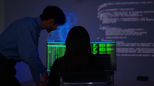 Software engineers collaborating on cybersecurity monitoring and AI powered code analysis in a modern technology workspace with multiple digital displays