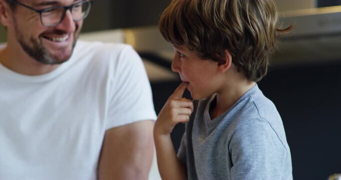 Baking, taste and father with child in kitchen learning cooking skills, child development and teaching to bake. Home, family and dad with son tasting mix for cake, food or snack for morning breakfast