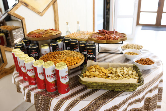 Horn Premium Lager and Horn Diesel beer cans displayed with snacks and meat platters at a festive buffet.