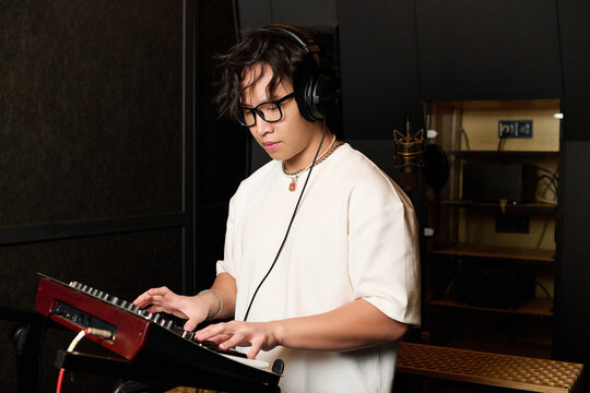 Creative young man crafting music in a recording studio setting