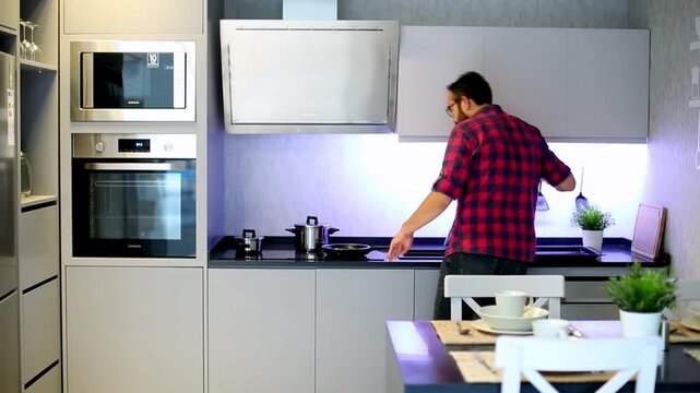 Man in Plaid Shirt Opening Oven Door While Preparing Food in Modern Kitchen

Young Man Cooking in Modern Grey Kitchen Interior With Built-in Appliances

Back View of Man Using Oven in Contemporary Kit