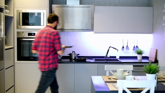 Man in Plaid Shirt Opening Oven Door While Preparing Food in Modern Kitchen

Young Man Cooking in Modern Grey Kitchen Interior With Built-in Appliances

Back View of Man Using Oven in Contemporary Kit
