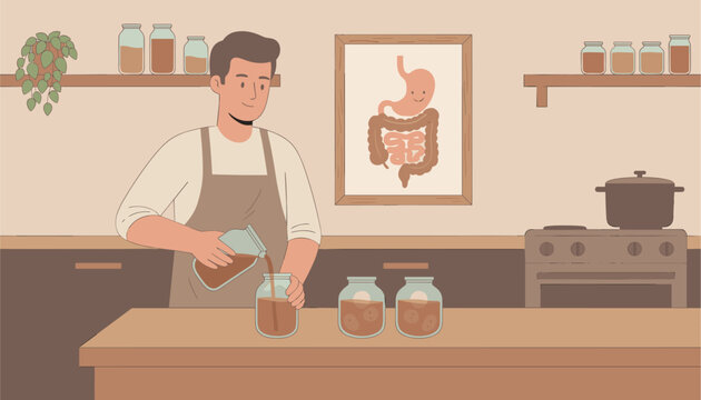 Man wearing an apron pouring liquid into glass jars in a kitchen with a digestive system wall poster.