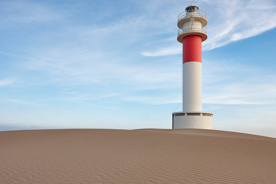 Picturesque lighthouse surrounded by dunes Fangar. Delta Ebro, Tarragona. Spain