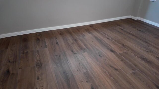 Natural wood laminate parquet floor. Room with floating laminate in new apartmen. Cozy home interior, modern design