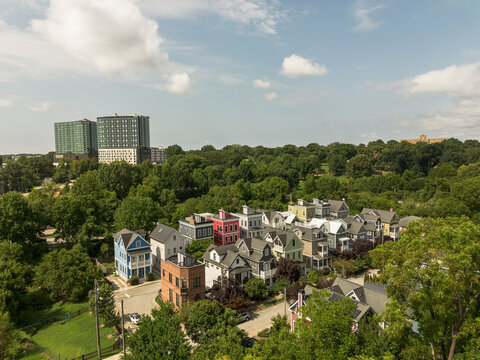 New colorful homes near downtown Raleigh, North Carolina with Dix Park and highrise apartments in the distance