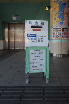 Signboard indicating the 20-yen fee for pushing bicycles and the toll box at the entrance of the Kanmon Pedestrian Tunnel in Shimonoseki, Japan, May 13, 2026
