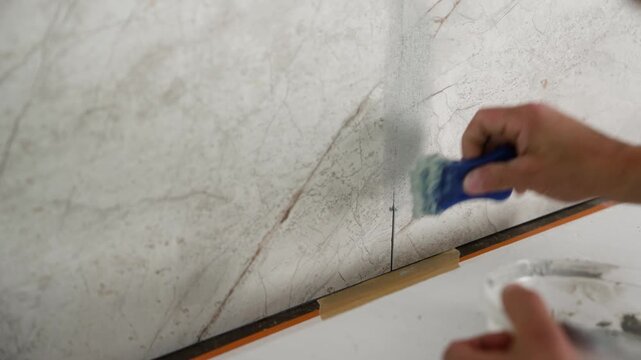 The process of applying epoxy grout. Epoxy grout for kitchen tiles.