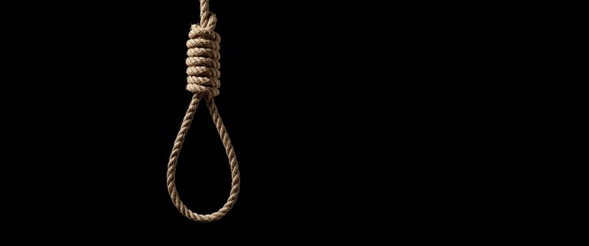 Rope Noose Hanging Against a Black Background in Dim Lighting