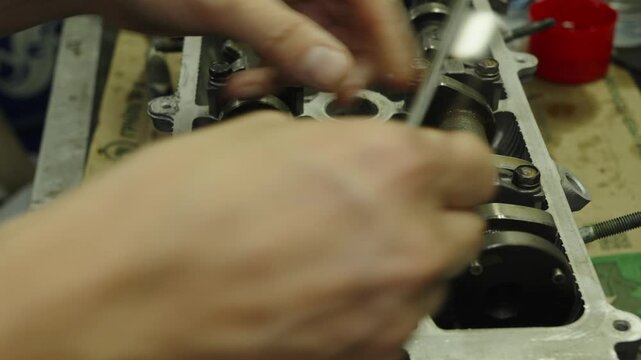 Mechanic holding a feeler gauge set to measure engine clearances.