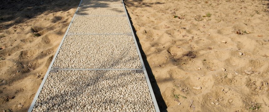 Stone Pathway Leading Through Sandy Terrain Under Soft Natural Light