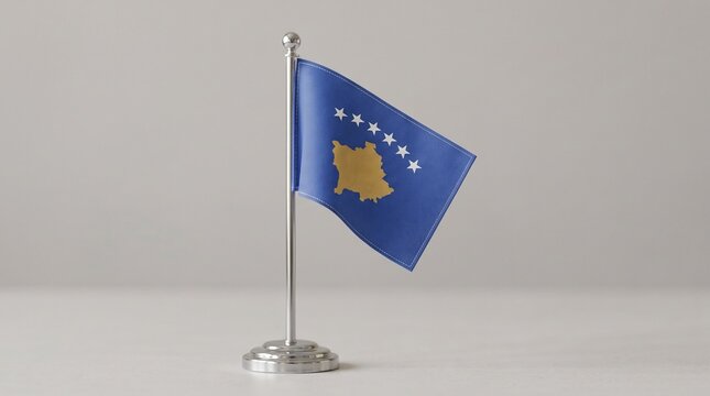 Kosovo desk flag on silver stand, blue field with golden map and six white stars, symbolizing sovereignty, unity, and cultural identity on rustic wooden surface.