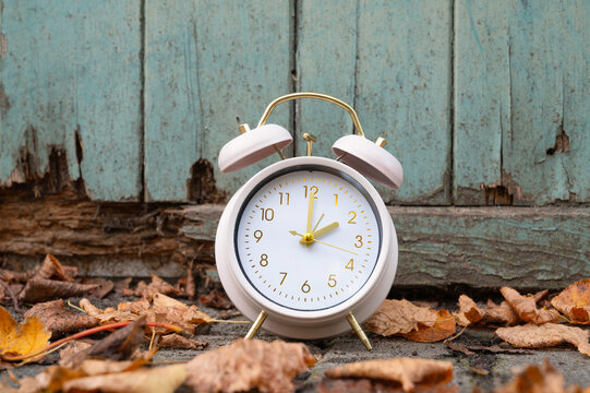 End of daylight saving time in autumn, winter time changeover, alarm clock fall back switch, colorful foliage, backyard