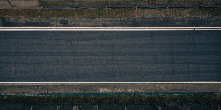 Aerial View of an Empty Asphalt Racetrack with Fencing at the Edge