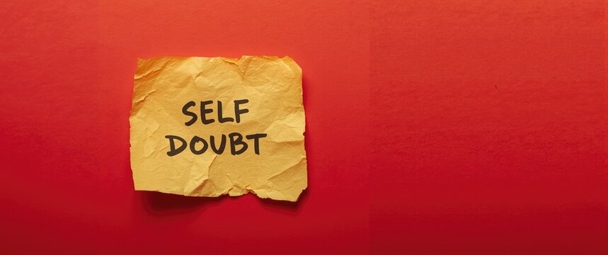 Crumbled Note with Self Doubt Message on Red Background
