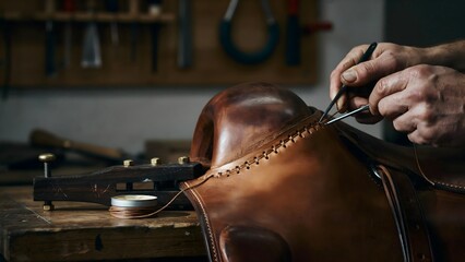 Obraz premium Expert cobbler stitching and repairing leather shoes in workshop setting