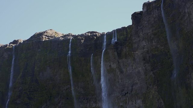 Casta&ntilde;o Overa glacier and cascading waterfalls flowing down a rocky cliff in Nahuel Huapi National Park, Argentina, showcasing glacial ice and mountain water.