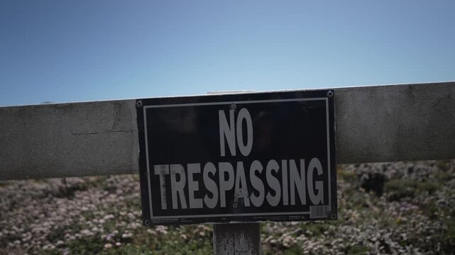 Sign warns against trespassing at Point Arena Lighthouse to protect the vegetation along the coast near Mendocino California