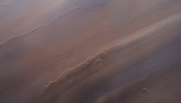 Close-up view of a textured reddish-brown surface with diagonal patterns and subtle tonal variations.