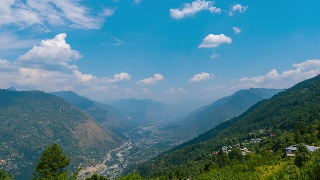 4K Timelapse of clouds moving above the Kullu and Bhuntar city during monsoon season. Mountain landscape. View of the Himalayas during sunny day. Travel and holidays concept.