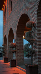 Fototapeta premium Historic brick arches with decorative trees at dusk