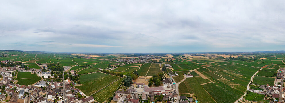 Aerial panorama of Meursault, Burgundy, France, featuring Chardonnay vineyards, viticulture, wine production, agriculture, and the village surrounded by cultivated fields.