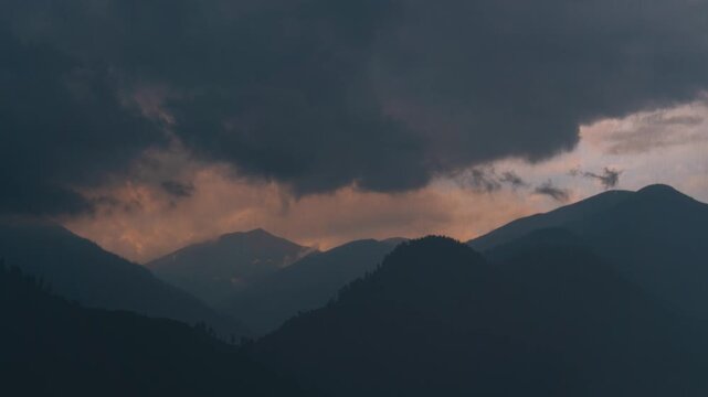 4K timelapse of dramatic mountain landscape and rain with dark clouds in sky at Manali, Himachal Pradesh, India. Stormy weather during sunset in Himalayas. Monsoon landscape. 