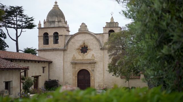 Explore the mission church in Carmel California with views of its structure and nearby trees and plants.