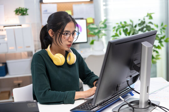 Young businesswoman working on laptop in modern office. Professional using computer for project planning, business management, and workplace productivity.