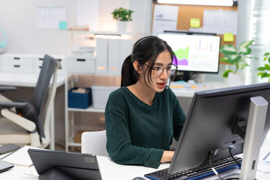 Young businesswoman working on laptop in modern office. Professional using computer for project planning, business management, and workplace productivity.