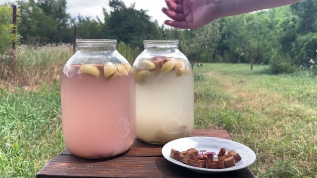 throwing rye bread into a jar, making kvass outdoors. High quality 4k footage