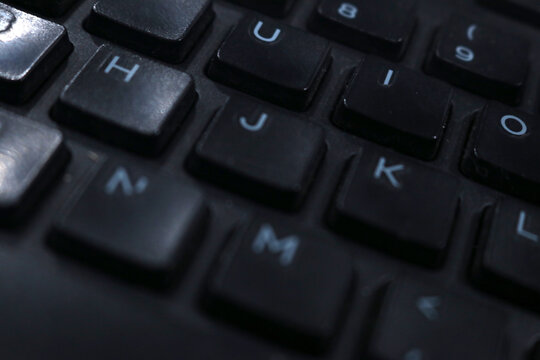 A photo of a black computer keyboard on an office desk.