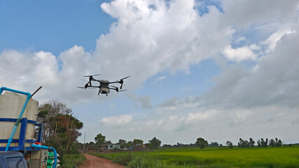 Fototapeta premium Agriculture drone fly to sprayed fertilizer on the rice fields. Industrial agriculture technology.