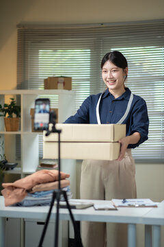 Young Asian Woman Live Streaming Online Shop Holding Cardboard Box for E commerce Small Business