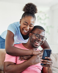 Fototapeta premium Happy young couple having fun using smartphone during oline video call conversation or shopping or using an app at home