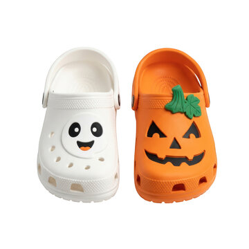 Pair of halloween themed clogs with ghost and pumpkin charms isolated on transparent background