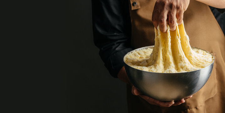 Baker Stretching Fermented Bread Dough Before Baking