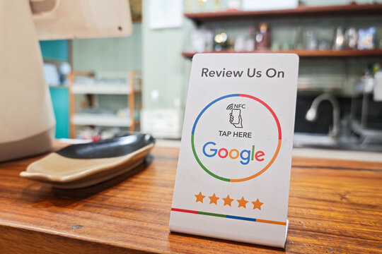 Bangkok, Thailand - 23 July 2026; A review tag with NFC technology inside, using smartphone to tap for review this restaurant on Google. New technology for business working is presented.