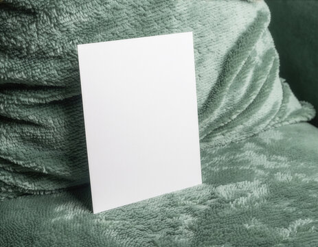 Blank vertical card mockup template on green textured fabric