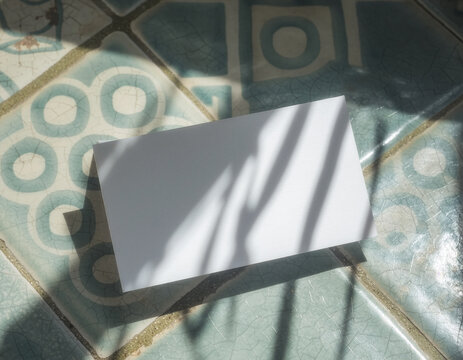 Blank business card mockup template on patterned ceramic tile