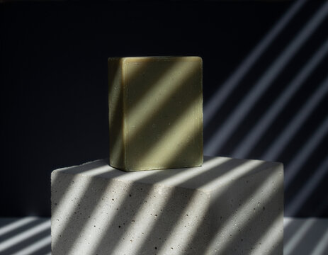 Olive oil soap bar mockup template on concrete cube with striped shadows