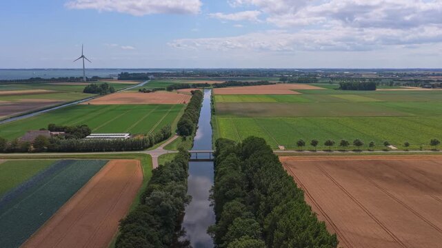 Aerial view of dutch canal and wind turbine in a rural landscape