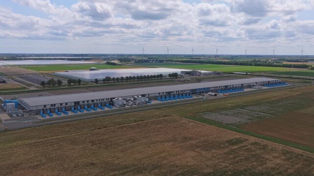 Aerial view of google data center in rural landscape with wind turbines